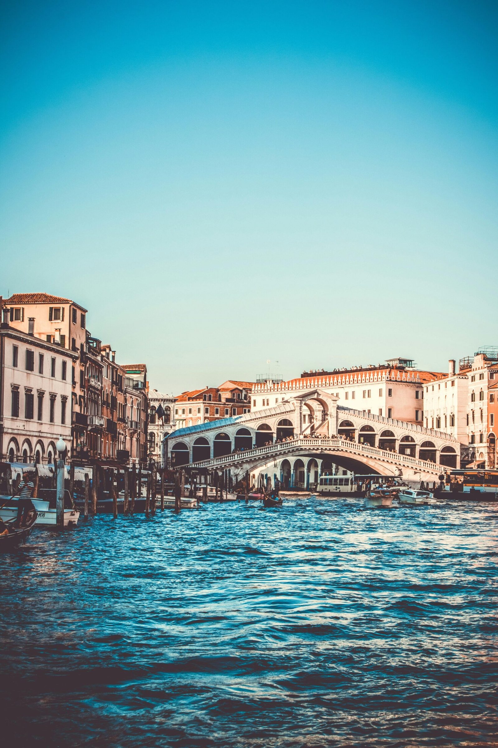 Explore the iconic Rialto Bridge over the Grand Canal in Venice, a must-visit tourist spot.